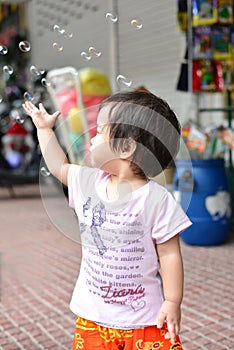 Baby girl play soap bubble