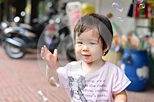 Baby girl play soap bubble