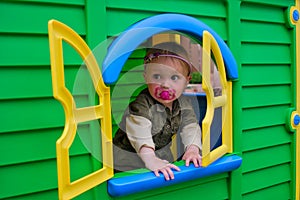 Baby girl in playhouse window