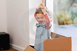 baby girl playing with cardboard box at home