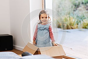 baby girl playing with cardboard box at home