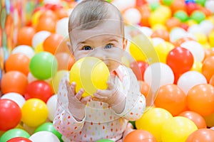 Baby girl playing with colorful balls