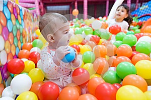 Baby girl playing with colorful balls