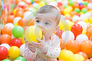Baby girl playing with colorful balls