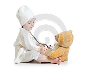 Baby girl playing doctor with teddy bear