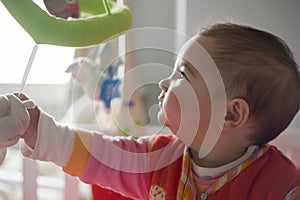 Baby girl playing with her baby musical mobile toy