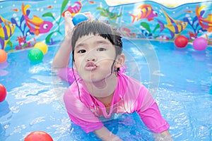 Baby girl playing in kiddie pool