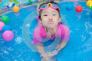 Baby girl playing in kiddie pool