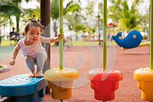 Baby girl playing at playground in the park