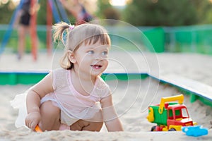 Baby girl playing in sandbox in kindergarten.ittle girl plays with toys in the sand.