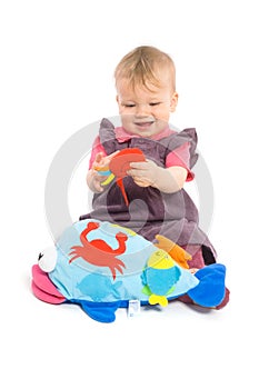 Baby girl playing with toy - isolated