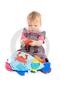 Baby girl playing with toy - isolated
