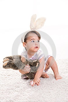 Baby girl playing with toy rabbit