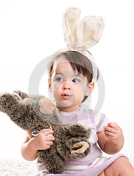 Baby girl playing with toy rabbit