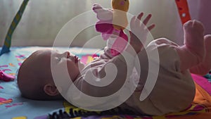 Baby girl playing with toys in bedroom. Happy family concept. Beautiful baby plays with toys indoors.