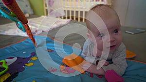 Baby girl playing with toys in bedroom. Happy family concept. Beautiful baby plays with toys indoors.