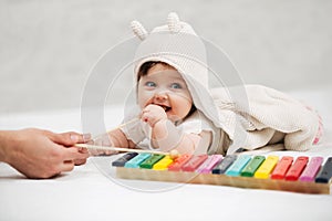 Baby girl playing with xylophone toy at home