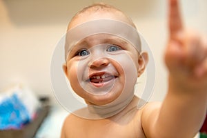 Baby girl pointing his finger straight to the camera. Cute adorable baby after bath time