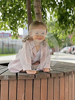 baby girl portrait sitting on the bench in