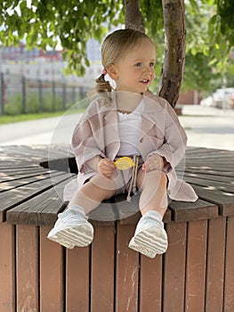 baby girl portrait sitting on the bench in