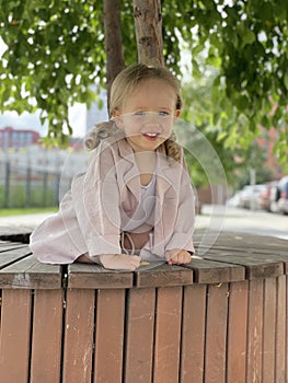 baby girl portrait sitting on the bench in