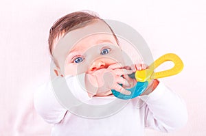 Baby girl with rattle teether toy.