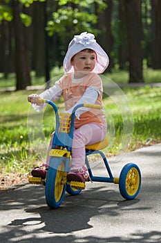 Baby girl rides tricycle