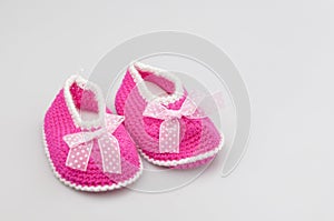 Baby girl shoes on white background, banner, copy space. Knitted baby booties