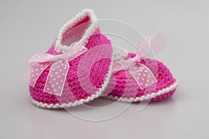 Baby girl shoes on white background, banner, copy space. Knitted baby booties