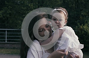 Baby girl sitting on the mom`s hands