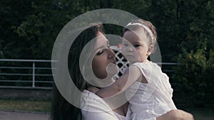 Baby girl sitting on the mom`s hands