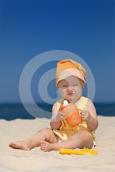 Baby girl sitting on the sandy beach