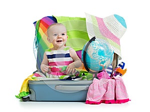 Baby girl sitting in suitcase with globe
