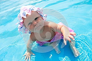 Baby girl sitting in waterpool