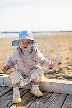 Baby girl sitting on wooden pier