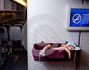 Baby girl sleep in a bassinet on a airplane