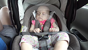 Baby girl sleeping in child car seat.