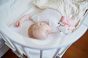 Baby girl sleeping in co-sleeper crib