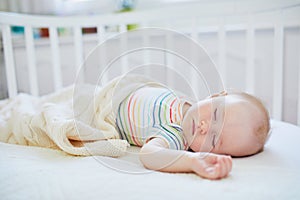 Baby girl sleeping in co-sleeper crib