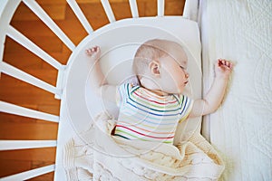 Baby girl sleeping in co-sleeper crib