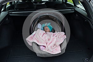 Baby girl sleeping in a safety child car seat. 3 months old baby girl. Protection concept, safety, and security