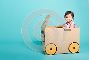 Baby girl smile in driving play car creative by a cardboard box