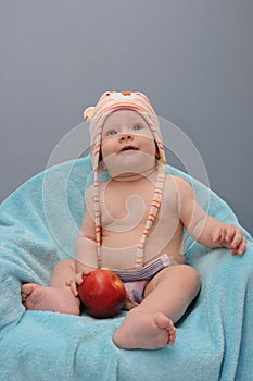 Baby girl smiles and hold the apple