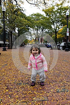 Baby Girl Smiling at Autumn Foliage