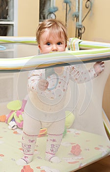 Baby girl stand in playpen