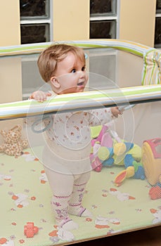 Baby girl stand in playpen