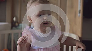 Baby girl standing and dancing in the crib