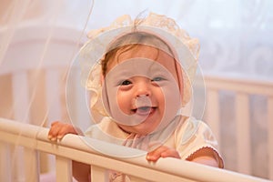 Baby girl standing in her crib.