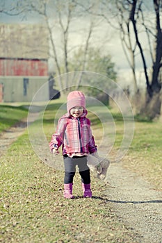 Baby Girl Standing Holding Teddy Bear