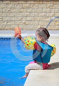 Baby girl by swimming pool